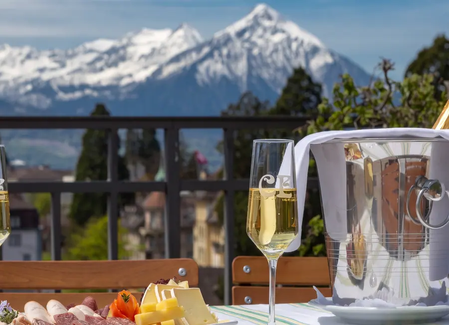 Schaumwein im Kühler auf der Dachterrasse, dahinter der Niesen