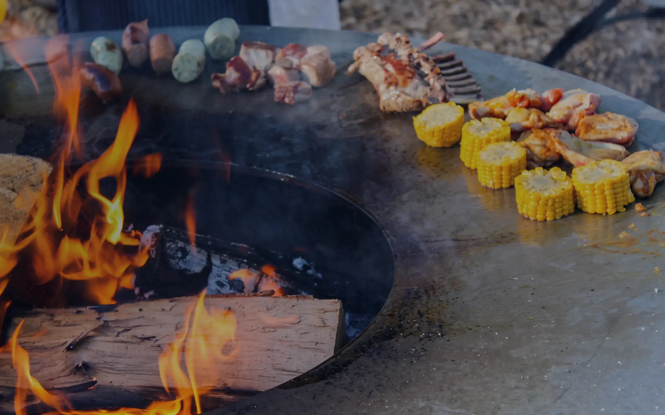 Cercle de feu avec viande, épis de maïs et légumes