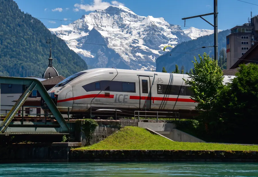 Zug auf der Aarebrücke in Interlaken, dahinter die Jungfrau