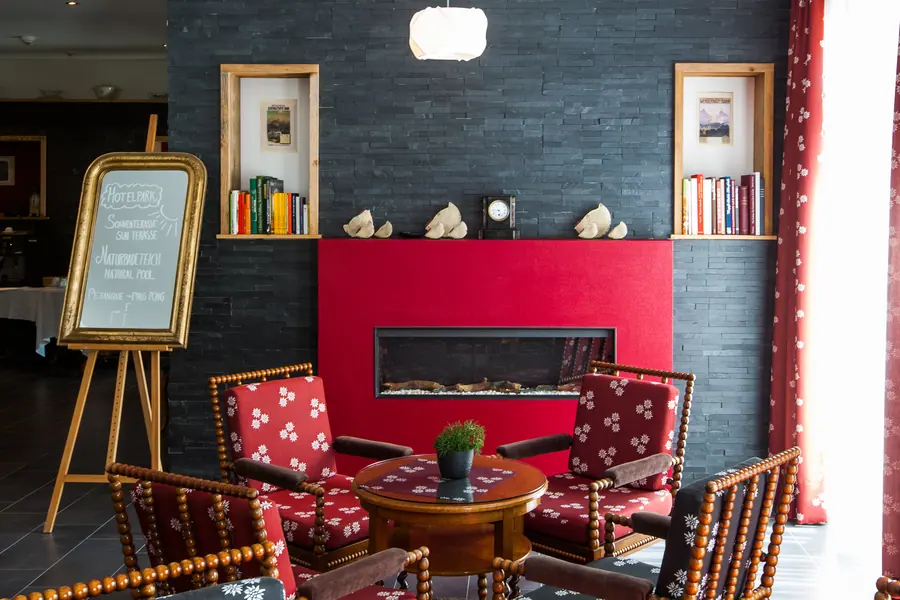 Roter Kamin mit Polsterstühlen in der Hotelhalle
