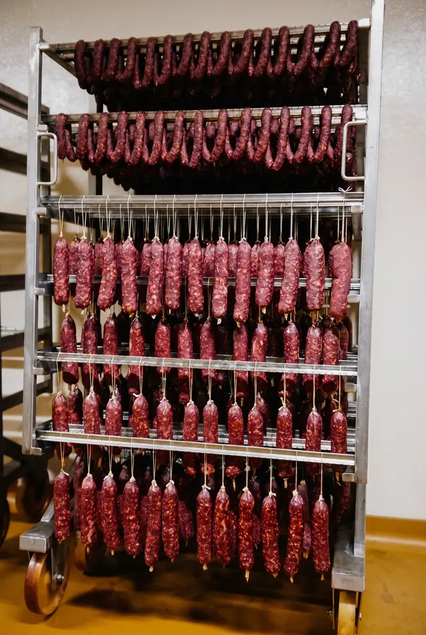 Salamis maison qui sèchent sur un chariot de la boucherie Blaue Kuh