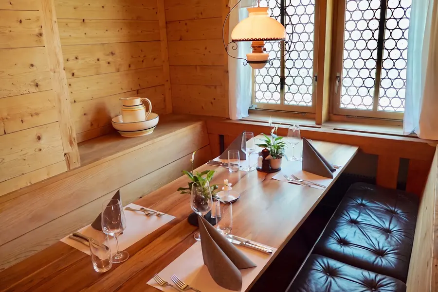Laid table by the window in the Arvenstube of the Chalet Beizli