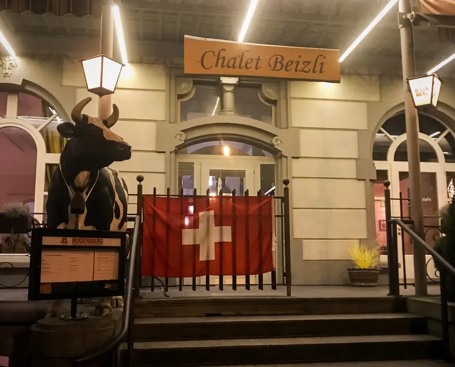 Entrance of the Chalet Beizli with cow and Swiss flag