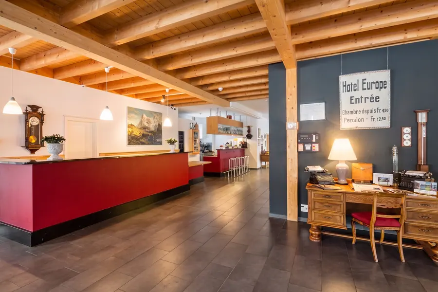 Empfang des Hotels mit roter Theke und Holzbalkendecke