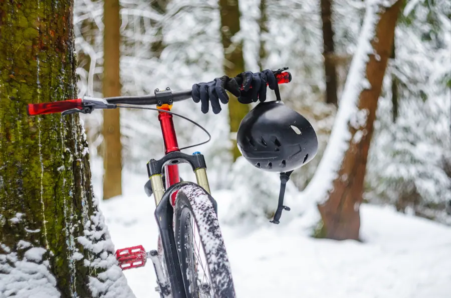 Mountainbike mit Helm im verschneiten Wald