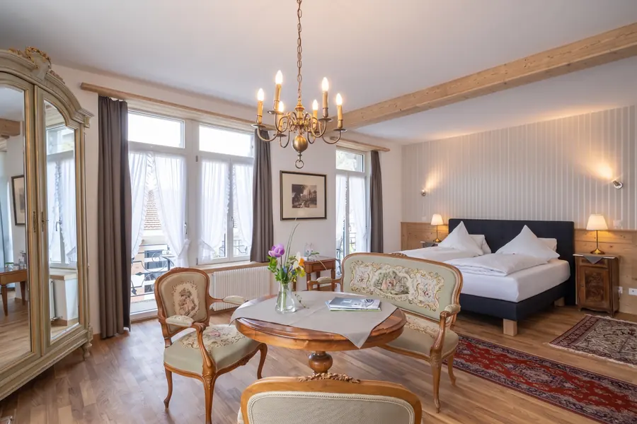 Suite avec lustre, fauteuils et grandes fenêtres