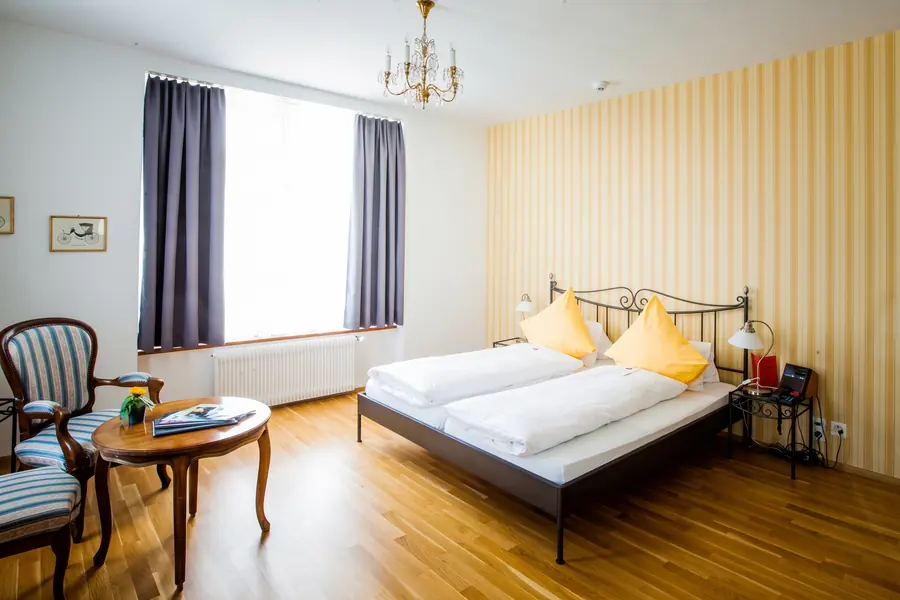 Chambre avec paroi à rayures jaunes et lustre